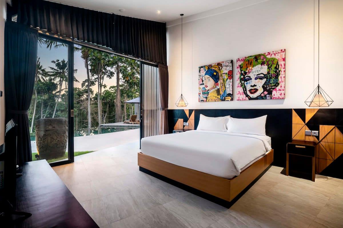 Modern bedroom illuminated by daylight with a jungle view 