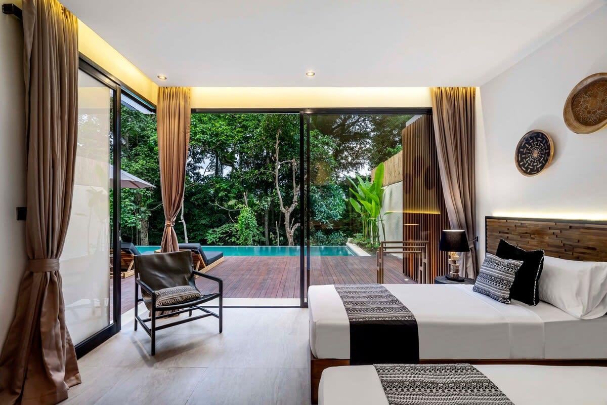 Twin bedroom with a side pool view and wooden terrace