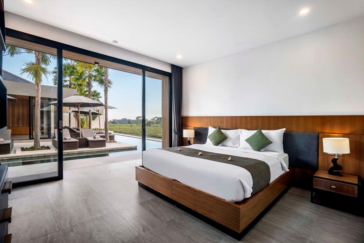 Modern bedroom with a side pool view 