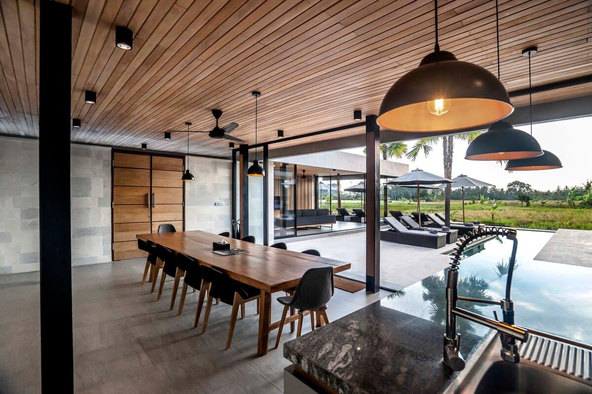 View of the dining area and kitchen overlooking the lounging and pool area