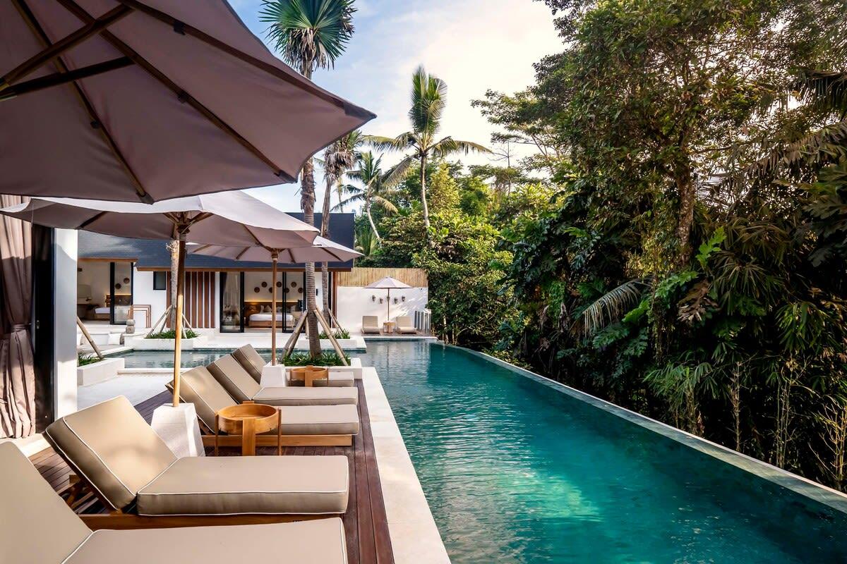 Sideview of the villa’s front area with a turquoise pool and jungle view