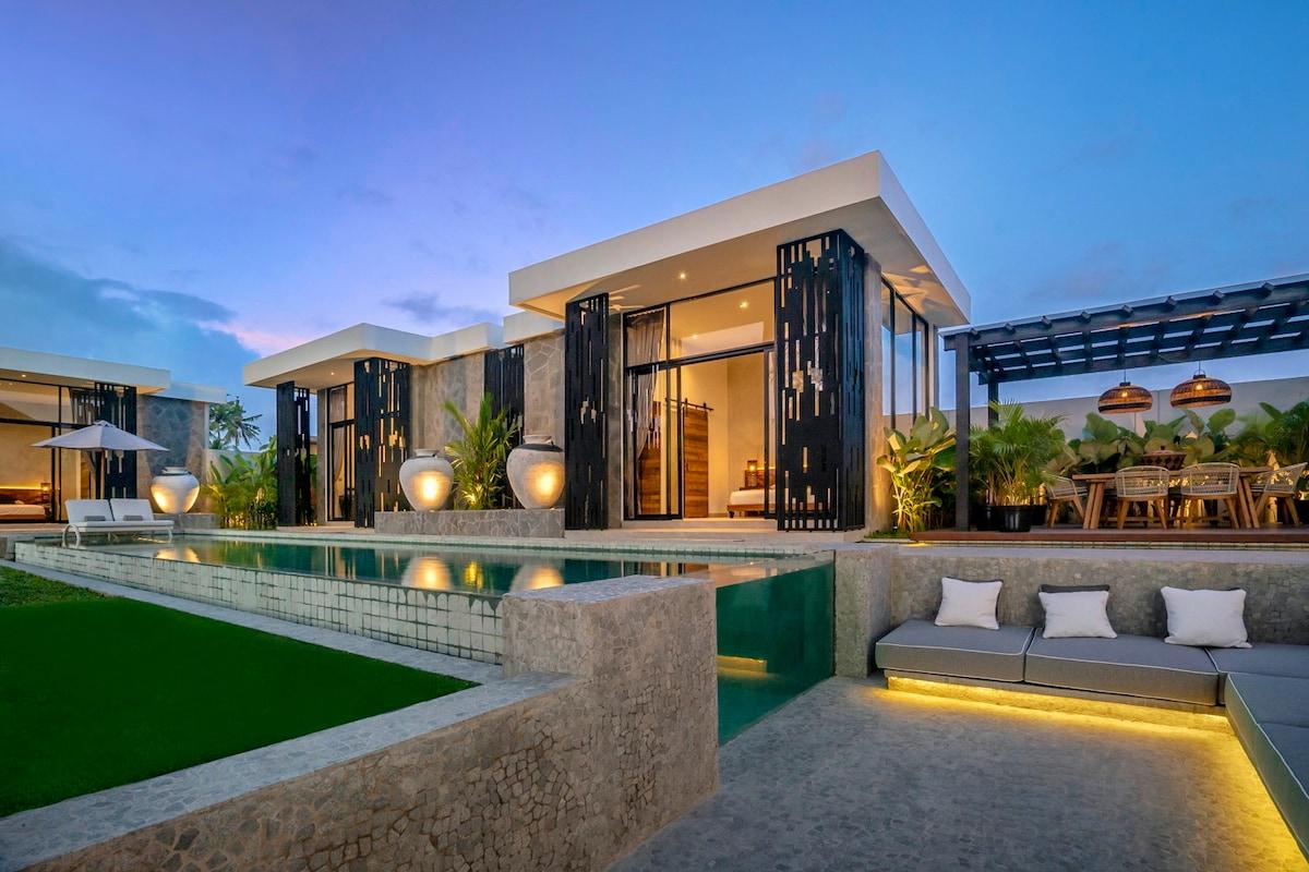 View of the outside sitting area overlooking the illuminated villa 